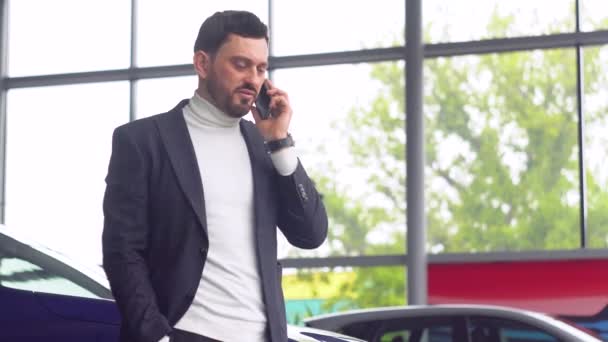 Autohaus-Manager erklärt sich bereit, ein Auto zu verkaufen. Verkäufer bespricht die Details der Transaktion telefonisch — Stockvideo