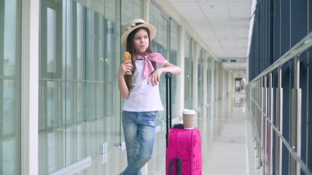 Kleine Mädchen essen Fast Food und am Flughafen, während sie auf das Flugzeug warten. Flugverspätung — Stockvideo