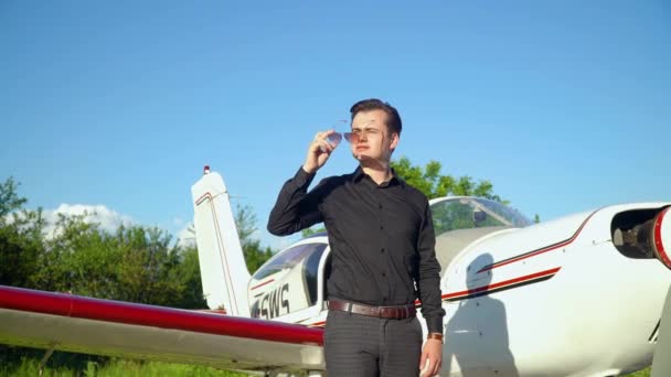 Egy elegáns öltönyös üzletember a repülője mellett a repülés előtt. — Stock videók