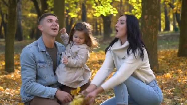 Jovem família feliz se divertir em folhas de outono. Queda — Vídeo de Stock