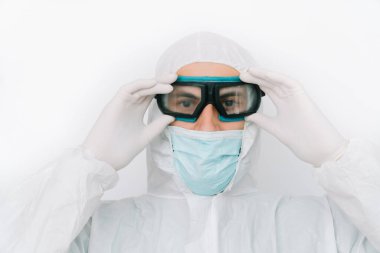 Dezenfektan güvenlik gözlüğü takar. Ofis binasında çalışan koruyucu giyimli ve maskeli bir virüs uzmanı.