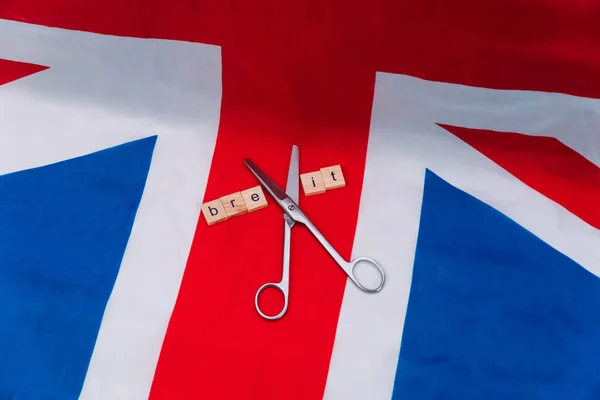 UK flag with the inscription brexit and scissors. Brexit in the UK