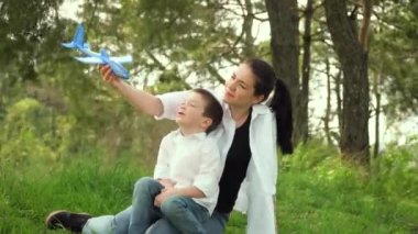 Anne ve oğlu hafta sonu parkta oyuncak uçakla oynuyorlar. Mutlu bir çocukluk. Anneler günün kutlu olsun.