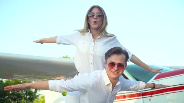 Pasangan bahagia di depan pesawat kecil yang diparkir. Konsep kebahagiaan, bulan madu — Stok Video