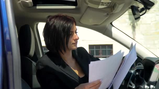 Jovem empresário com documentos num carro. Pessoas e conceito de negócio — Vídeo de Stock