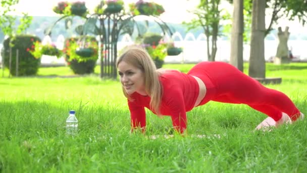 Vrouw oefening door planking yoga pose voor workout. Yoga fitness op park voor een goede gezondheid — Stockvideo