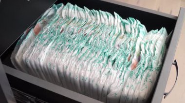 Babam bebek beziyle şifoniyerdeki rafı kapatıyor. Yakın plan, bebek bezi. Babalar Günü. Çocuk bakımı kavramı