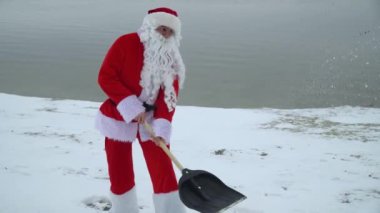 Noel Baba kışın kumsaldan kar temizler, kar fırtınasından yolu temizler.