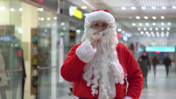 Papá Noel malo metiéndose en la nariz. Santa Claus en un gran centro comercial — Vídeo de stock