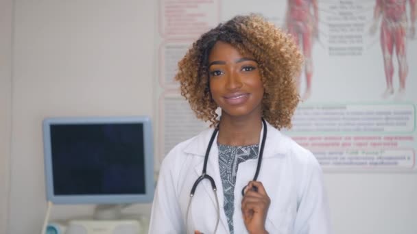 Ritratto di dottoressa afroamericana professionista con stetoscopio. Ospedale con ultrasuoni sullo sfondo. Fermare il virus — Video Stock