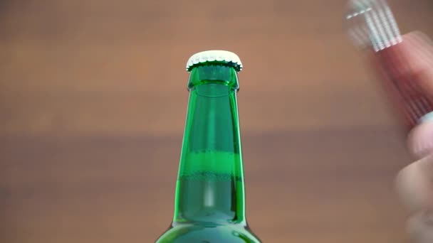 Una botella de cerveza es abierta por una mano masculina. Concepto de cerveza — Vídeos de Stock