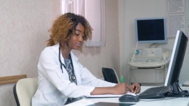 Arka planında ultrason cihazları olan Afrikalı Amerikalı stajyer öğrenci hastanede. Tıp, sağlık ve insan kavramı, çevrimiçi eğitim