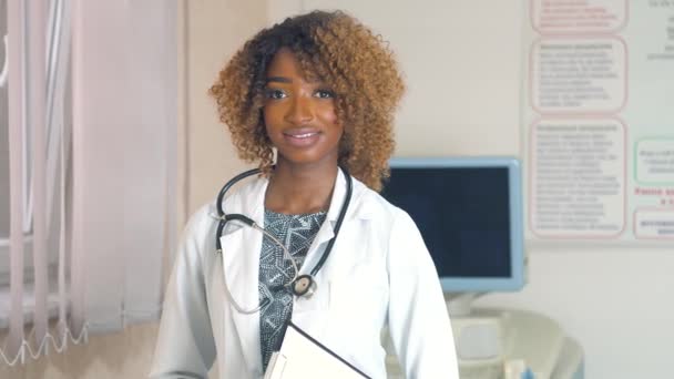 Retrato de médico profesional afroamericano con estetoscopio en el hospital con dispositivos de ultrasonido en el fondo. Detener virus — Vídeos de Stock