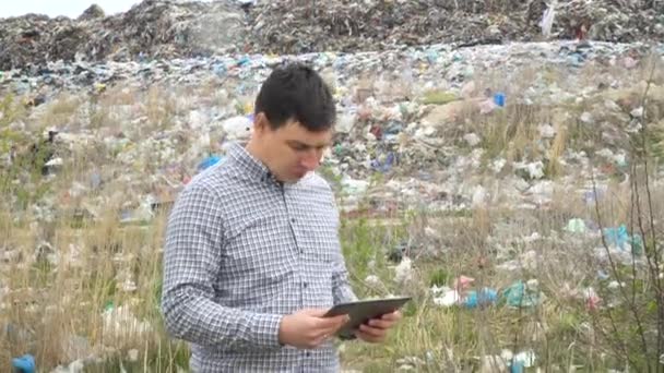 Garbage dump inspector with tablet records pollution level. Ecology pollution concept — Stock Video