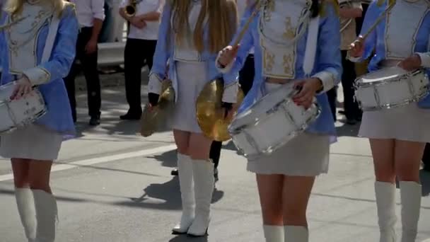 Actuación callejera de marcha festiva de bateristas niñas en trajes azules en la calle de la ciudad. Primer plano de las manos femeninas bateristas están golpeando en el tambor de sus palos — Vídeos de Stock