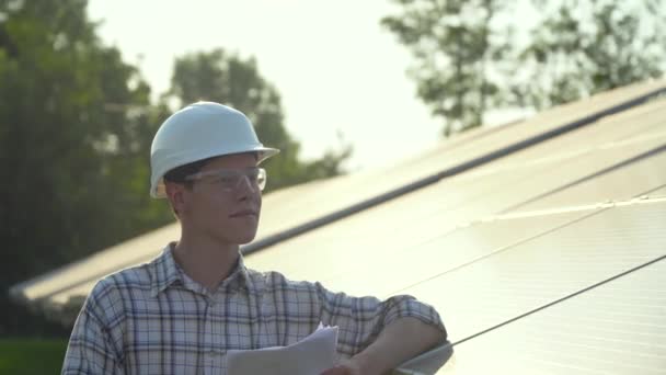 Beyaz kasklı mühendis güneş enerjisi istasyonunda. Yeşil enerji kavramı — Stok video