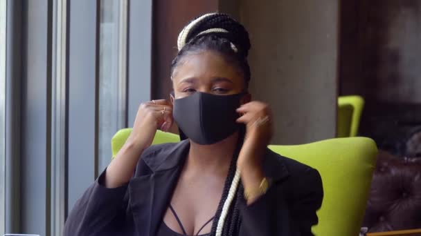 Menina afro-americana remove uma máscara médica. De volta ao trabalho com precauções sociais à distância. Fim da quarentena. Parar vírus — Vídeo de Stock