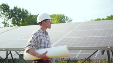 Beyaz kasklı mühendis güneş enerjisi istasyonunda. Yeşil enerji kavramı