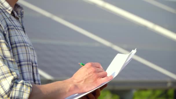 Крупный план рук инженера проверяет производительность солнечных батарей — стоковое видео