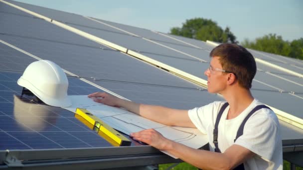 Inženýr ve speciálním zařízení je ve sluneční elektrárně. Koncept zelené energie — Stock video