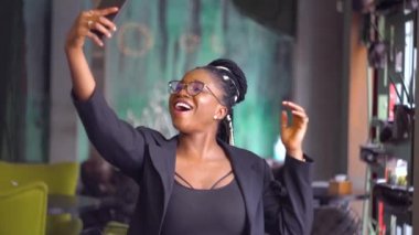 Zarif, güzel Afrikalı Amerikalı kız kafede selfie çekiyor. Karantinanın sonu