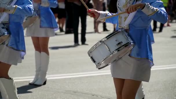 Actuación callejera de marcha festiva de bateristas niñas en trajes azules en la calle de la ciudad. Primer plano de las manos femeninas bateristas están golpeando en el tambor de sus palos. Majorettes y banda de marcha — Vídeos de Stock