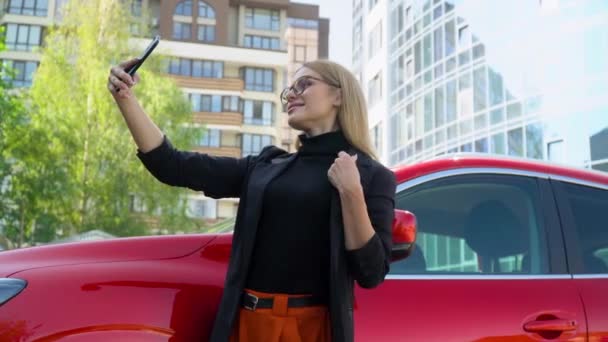 Elegantní úspěšná podnikatelka dělá selfie červené auto — Stock video