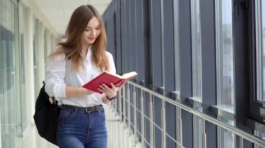 Üniversitede kitabı olan bir kız öğrenci. Sınav hazırlığı. Yeni modern tam işlevsel eğitim tesisi. Çevrimiçi eğitim kavramı