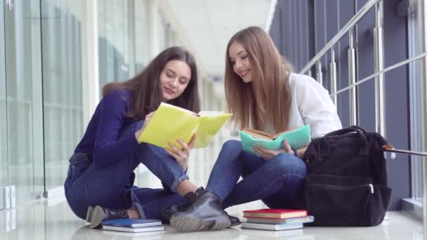 Twee vrouwelijke leerlingen met een boek op school. Begin van het schooljaar. Nieuwe moderne volledig functionele onderwijsfaciliteit. Concept van online onderwijs — Stockvideo