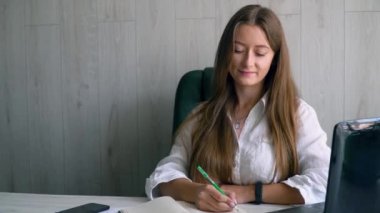 Çevrimiçi öğretmen kavramına sahip uzaklık dili kursu. Kız öğrenci bir deftere monitörden bir dil dersi yazar. Çevrimiçi eğitim kavramı