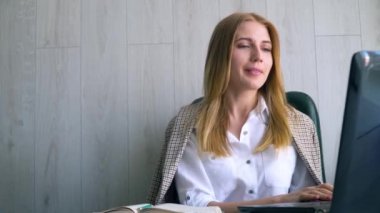 Konferans görüşmesiyle iletişim kuran Kafkas 'lı mutlu genç kadın merkez ofisteki bilgisayara bakıyor. Çevrimiçi öğretmen kavramına sahip video sohbet iş görüşmesi veya uzaklık dili kursu