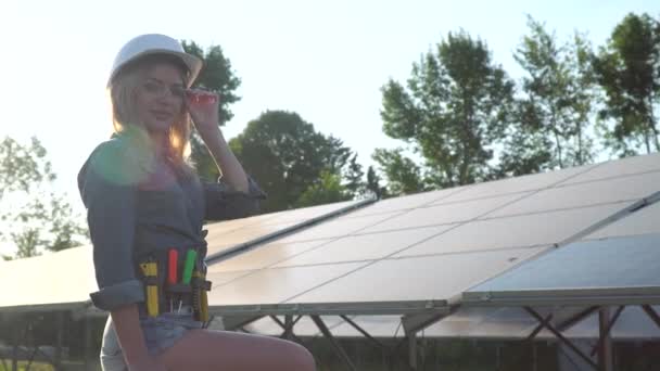 Uma engenheira num capacete branco está na central solar. O conceito de energia verde — Vídeo de Stock