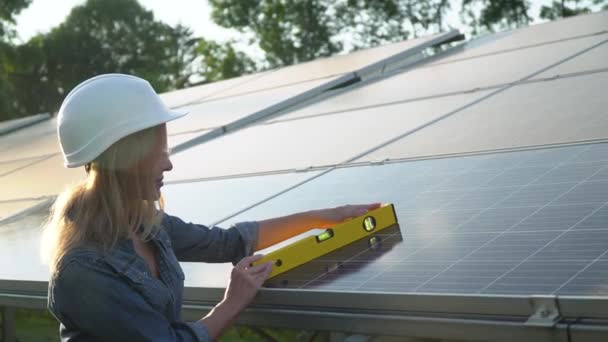 Engenheira inspetora em um capacete branco verificar o nível vertical do painel solar por nível de espírito. O conceito de energia verde — Vídeo de Stock