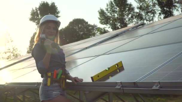 Engenheira em um capacete branco com chave de fenda está na central solar. O conceito de energia verde — Vídeo de Stock