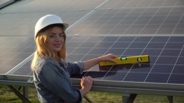 Ingeniera inspectora femenina en casco blanco comprobar el nivel vertical del panel solar por nivel de espíritu. El concepto de energía verde — Vídeo de stock