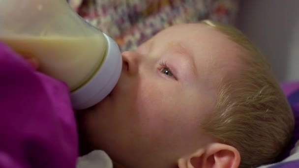 Mom feeds a little boy milk in bed. Caring for a small child — Stock Video