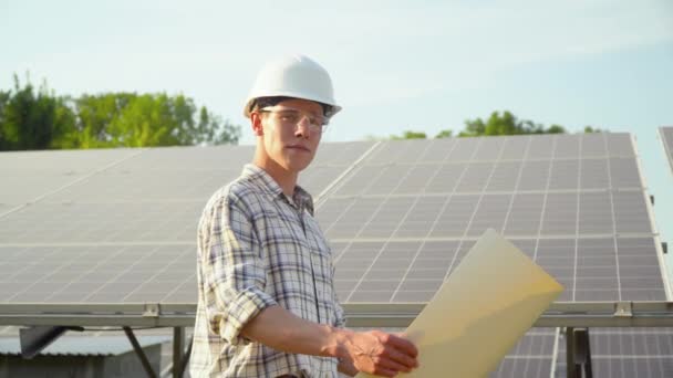 Инженер в белом шлеме на солнечной электростанции. Зеленая энергетика. Фотоэлектрическая панель — стоковое видео