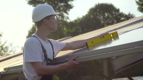 Genç makinist yeni güneşli bataryalar kuruyor. Yeşil enerji kavramı — Stok video