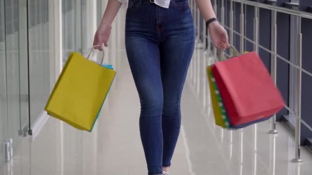 Chica joven con coloridas bolsas de compras en un centro comercial. Concepto de compras — Vídeos de Stock