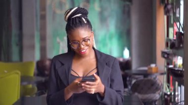 Genç siyahi bir kadın sevimli bir şekilde sohbet eder ve gülümser. Sevdiği ya da arkadaşıyla sohbet eder. Uzak mesafe ilişkisi