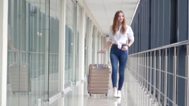 Kendine güvenen genç sarışın kız havaalanı terminalinde yürüyor. Şık kıyafetler, modern kadınlar. Yavaş çekim