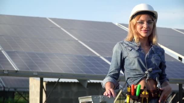 Ingenieurin mit weißem Helm steht am Solarkraftwerk. Alternatives Energiekonzept — Stockvideo