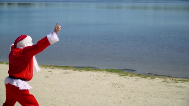 圣诞老人在海滩上玩得很开心，也在跳舞。圣诞节假期。热带地区的圣诞老人 — 图库视频影像