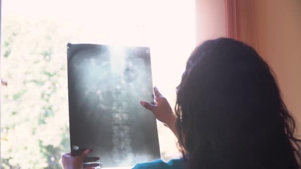 A női afro-amerikai orvos megvizsgálja a pajzsmirigy röntgenjét a klinikán. Pajzsmirigyrák diagnózisa. Az orvostudomány, az egészségügy és az emberek fogalma — Stock videók