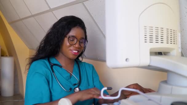Szczęśliwy profesjonalny afrykański położnik ginekolog wykonujący USG brzucha ciężarnej kobiety. Koncepcja medycyny, opieki zdrowotnej i ludzi — Wideo stockowe