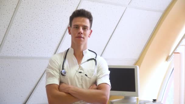 Portret van een lachende arts met stethoscoop in de kliniek. Ziekenhuis met ultrasone apparatuur op achtergrond — Stockvideo