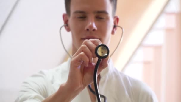 Young intern posing with stethoscope looking at camera in medical office. Concept of medicine, health care and people — Stock Video