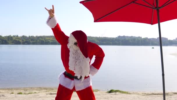Papai Noel está se divertindo e dançando em estilo rock na praia. férias de Natal — Vídeo de Stock