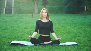 Genç Kafkas kadın parkta yoga yaparak rahatlıyor. Sağlıklı yaşam tarzı kavramı