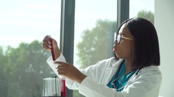 Kvinnlig afrikansk forskare läkare gör blodprov i laboratorium. Provning enligt steg 19 — Stockvideo